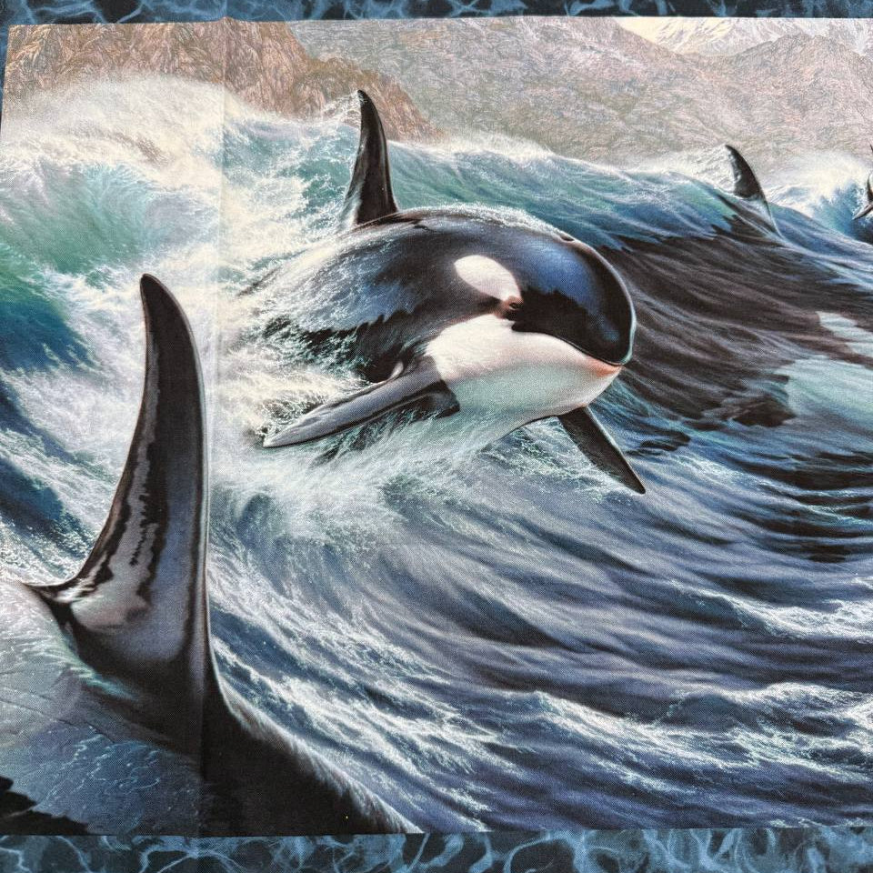 Northcott Naturescapes Voyage orca cotton fabric panel featuring killer whales swimming through blue ocean waves.