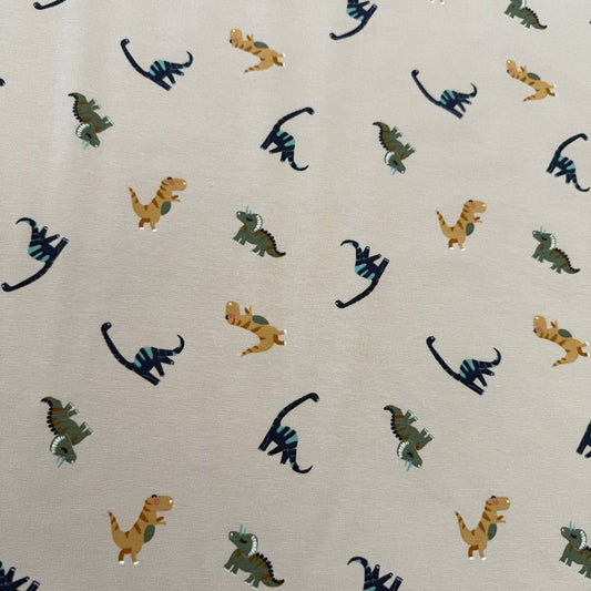 Sand cotton jersey knit fabric with colourful dinosaur print, 95% cotton and 5% elastane, 200 GSM.