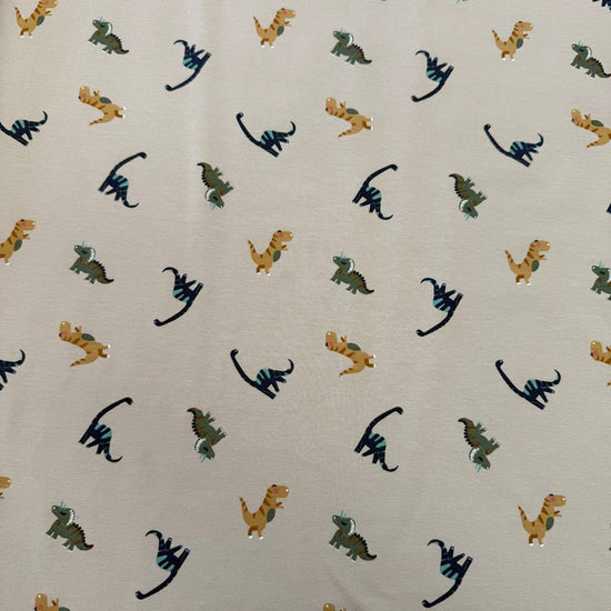 Sand cotton jersey knit fabric with colourful dinosaur print, 95% cotton and 5% elastane, 200 GSM.