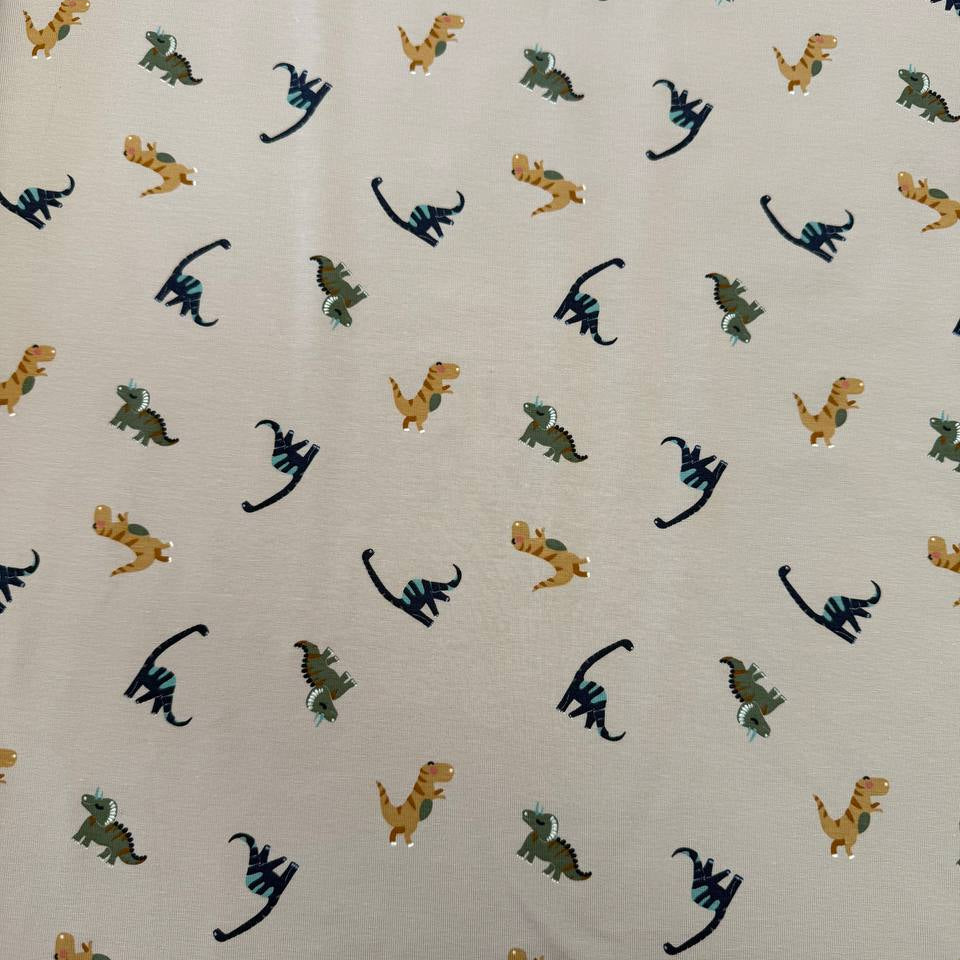 Sand cotton jersey knit fabric with colourful dinosaur print, 95% cotton and 5% elastane, 200 GSM.