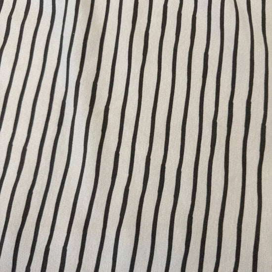 Sand cotton jersey knit fabric with colourful dinosaur print, 95% cotton and 5% elastane, 200 GSM.