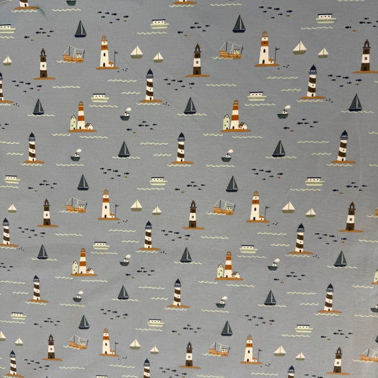 Dusty blue cotton jersey knit fabric with nautical boats, lighthouses and seaside print