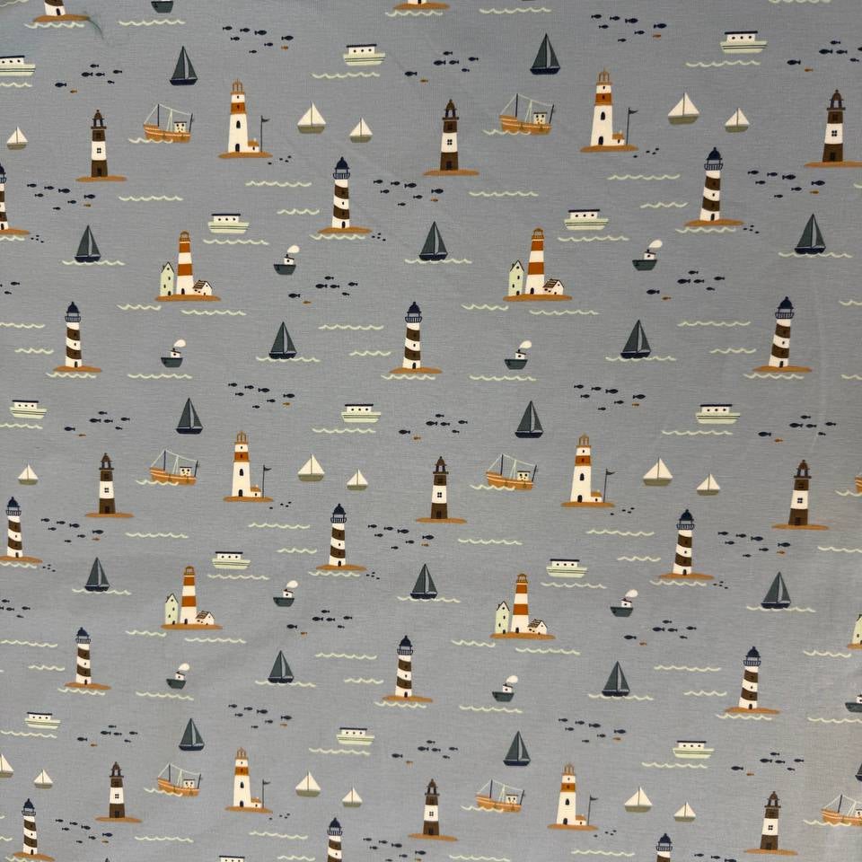 Dusty blue cotton jersey knit fabric with nautical boats, lighthouses and seaside print