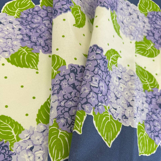 Classic Retro cotton toweling with blue and lavender hydrangeas, green leaves and blue border.