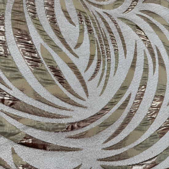 Shiny jacquard fabric in sand, champagne and gold tones featuring a textured abstract leaf pattern with metallic accents.