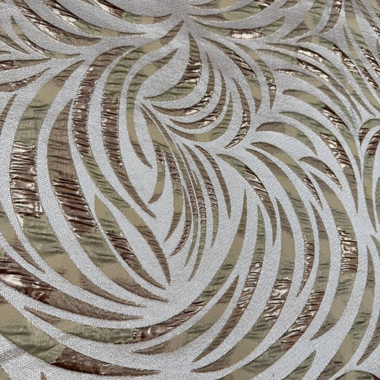 Shiny jacquard fabric in sand, champagne and gold tones featuring a textured abstract leaf pattern with metallic accents.