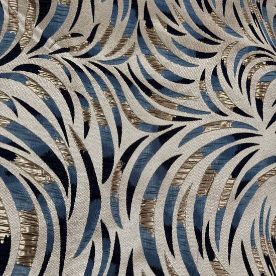 Shiny jacquard fabric in denim blue, navy and gold featuring a raised abstract leaf pattern with shimmering metallic details.