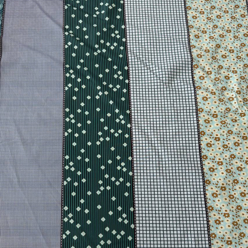 Gathered Lollies Moda cotton fabric featuring vertical patchwork-inspired stripes with floral, gingham and geometric patterns in teal, sage green, mint, blue and beige.