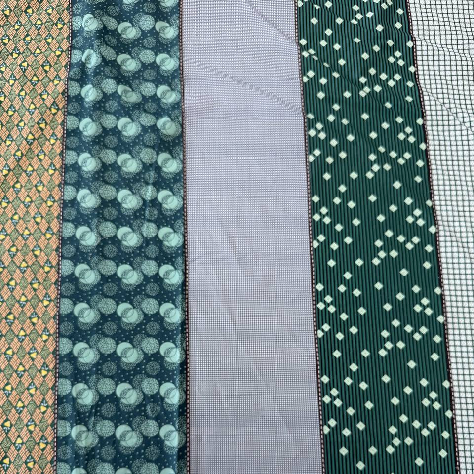 Gathered Lollies Moda cotton fabric featuring vertical patchwork-inspired stripes with floral, gingham and geometric patterns in teal, sage green, mint, blue and beige.