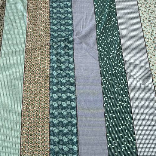 Gathered Lollies Moda cotton fabric featuring vertical patchwork-inspired stripes with floral, gingham and geometric patterns in teal, sage green, mint, blue and beige.