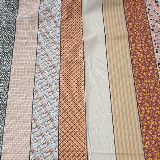 Gathered Lollies cotton fabric by Jen Kingwell for Moda featuring vertical patchwork-inspired stripes with floral and geometric prints in peach, terracotta, burgundy, cream and teal.