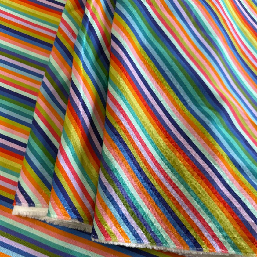 100% cotton quilting fabric from the Animal Alphabet collection by Lewis & Irene featuring colorful diagonal rainbow stripes on a white background.