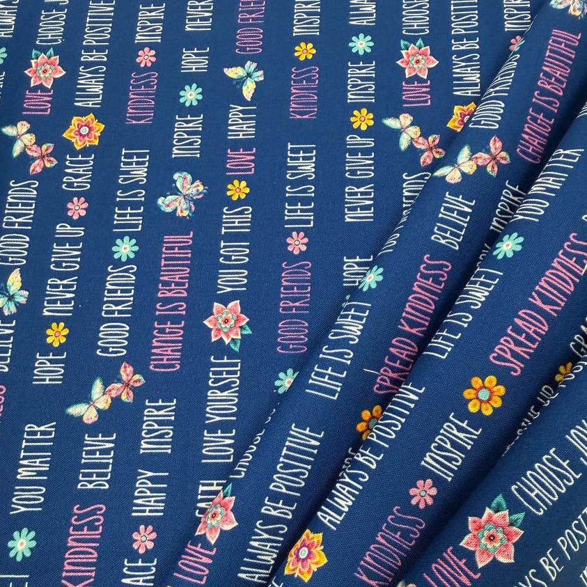 Navy blue 100% cotton quilting fabric featuring colorful inspirational words, butterflies, and flowers from the Faith & Grace collection by Kanvas Studio for Benartex.