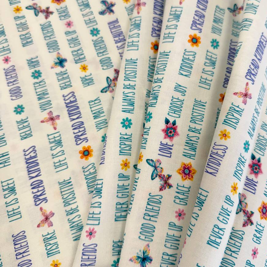 White 100% cotton quilting fabric featuring colorful inspirational words, butterflies, and flowers from the Faith & Grace collection by Kanvas Studio for Benartex.