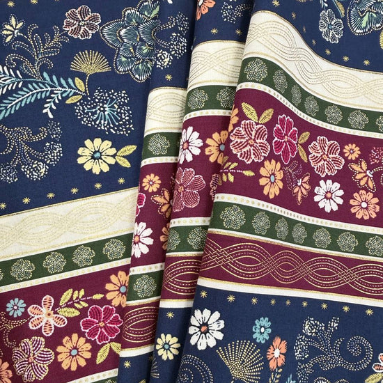 Majestic Garden Metallic Border Stripe quilting cotton by Kanvas Studio featuring decorative floral border stripes with metallic gold accents on a navy background.