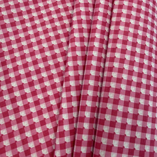 Smitten Chicken Check-A-Roo quilting cotton fabric by Poppie Cotton featuring a small gingham check with tiny white floral accents, available in Aqua and Pink.