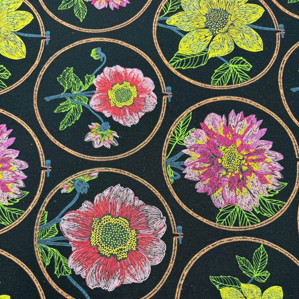 Anna Maria Textiles Silhouette Black floral fabric featuring colourful pink, yellow and coral flowers in embroidery hoop designs on a black background, 55% linen and 45% cotton.