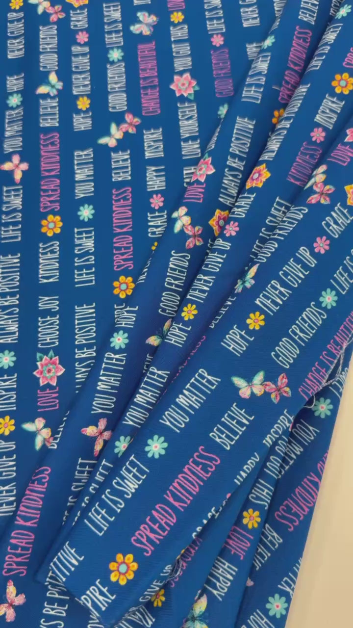 Navy blue 100% cotton quilting fabric featuring colorful inspirational words, butterflies, and flowers from the Faith & Grace collection by Kanvas Studio for Benartex.