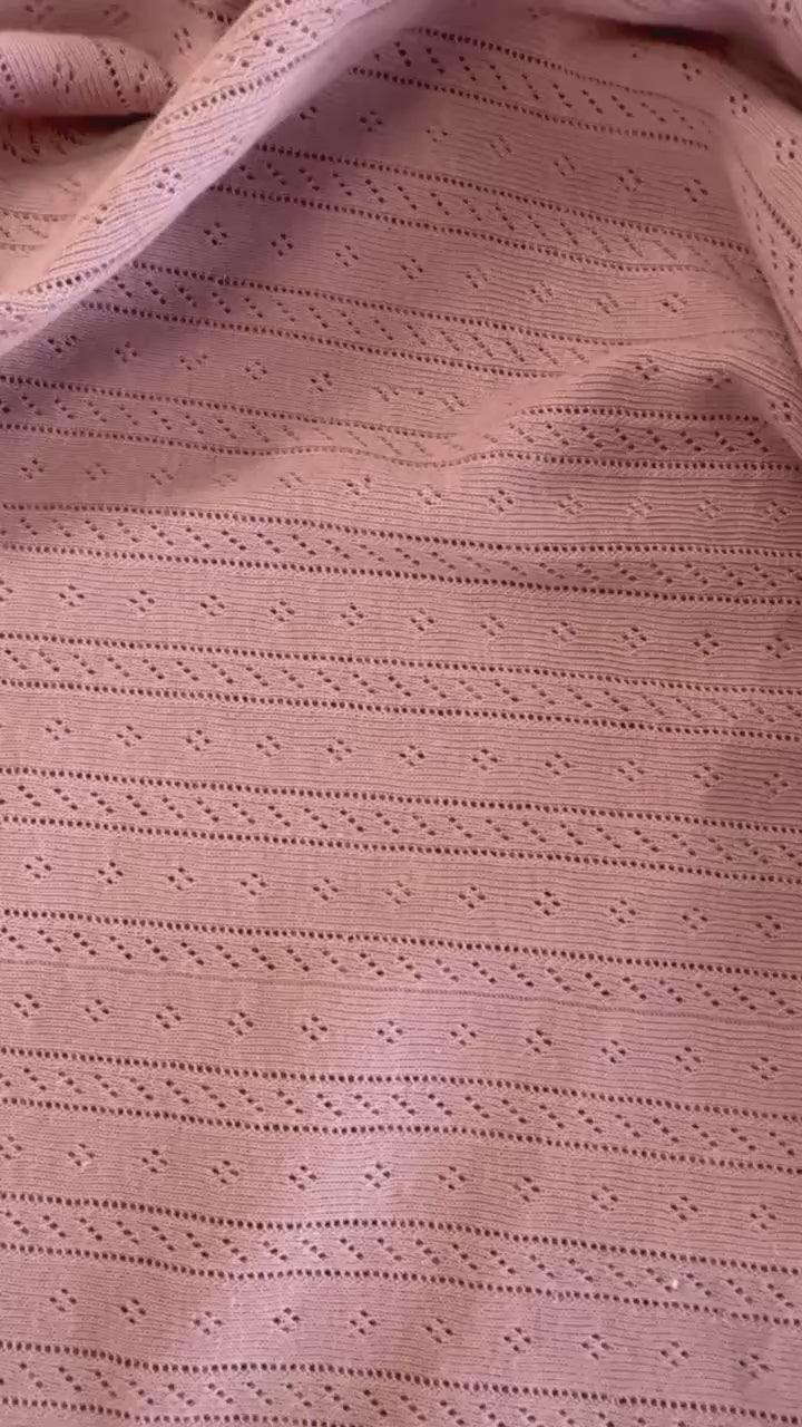 Dusty pink cotton pointelle knit fabric with delicate textured pattern