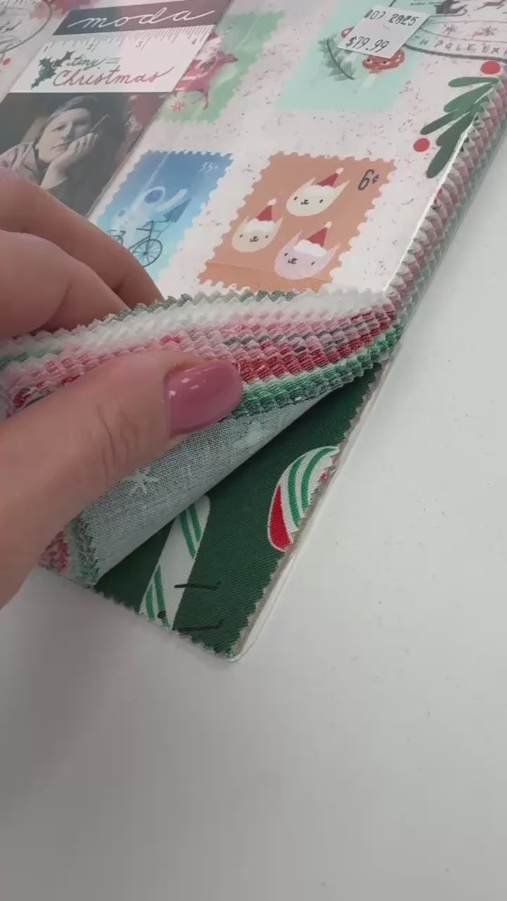 Tiny Christmas Layer Cake quilting fabric bundle by Moda Fabrics with Christmas postage stamp prints on cream background