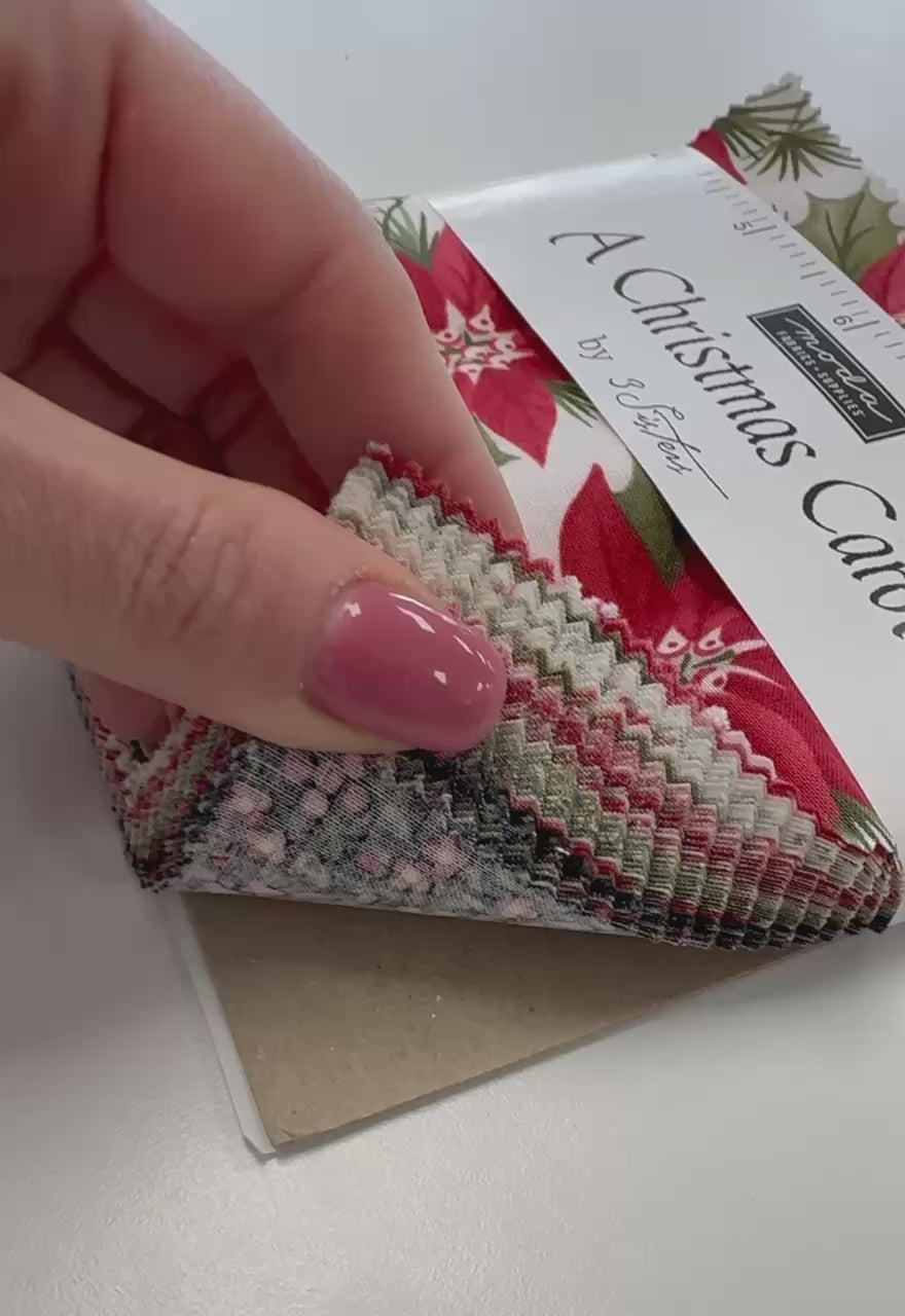 A Christmas Carol Charm Pack by 3 Sisters for Moda Fabrics featuring red poinsettia Christmas quilting cotton prints